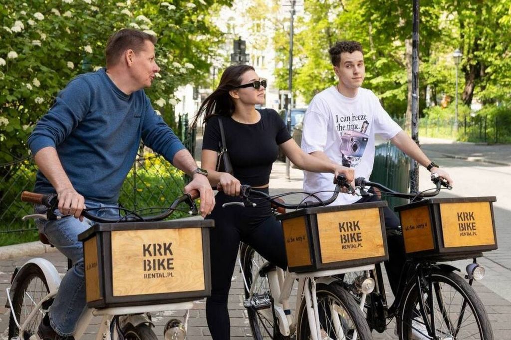 녹지 공원 근처에서 자전거 대여를 하고 있는 두 사람. 자전거에는 "Kirk Bike Rental" 이라고 적힌 나무 상자가 있습니다.