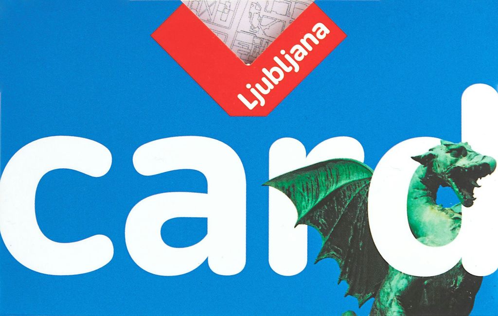 하얀 글씨로 '류블랴나' 라는 단어가 적힌 파란색 책 표지와 초록색 용의 날개를 그린 일러스트를 클로즈업한 사진.