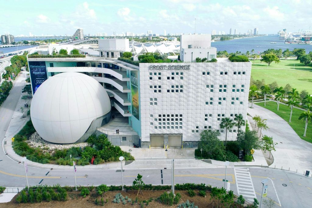 돔, 도시 주변 환경, 푸른 하늘 배경이 있는 현대 과학 박물관 건물의 공중 전망.