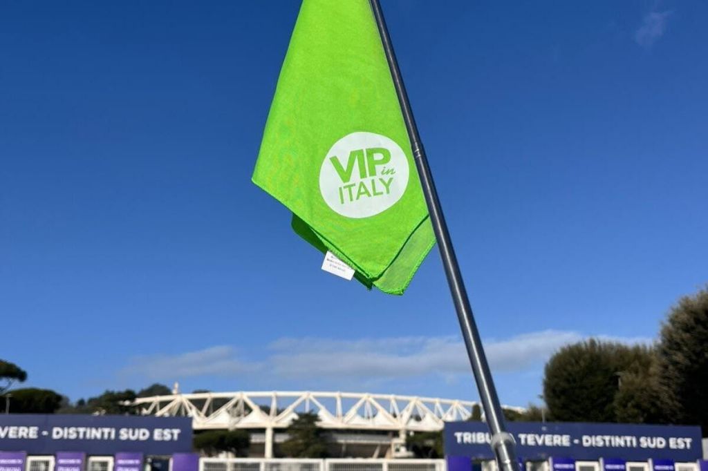 경기장과 푸른 하늘을 배경으로 'VIP in Italy' 라는 문구가 새겨진 녹색 깃발이 기둥에 걸려 있습니다.
