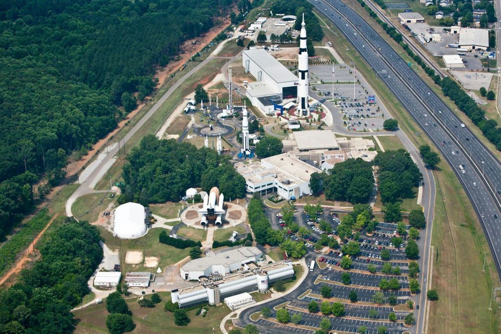 로켓, 우주 왕복선 모형, 건물, 주차장, 주변 나무가 있는 우주 센터의 공중 전망.