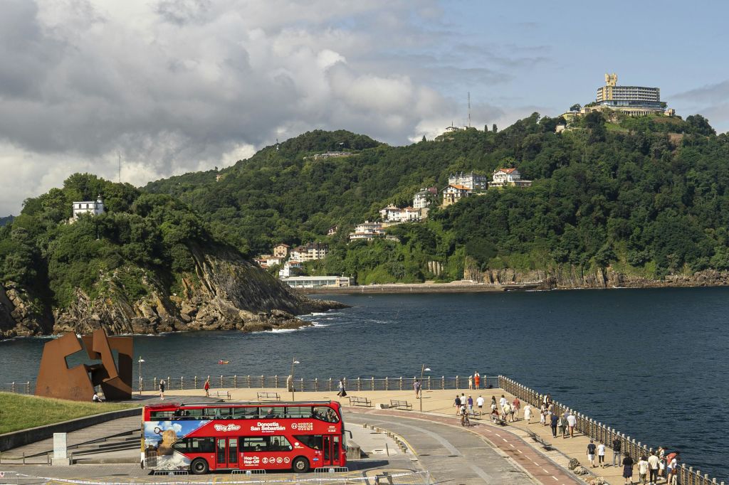 "도노스티아 산 세바스티안 (Donostia San Sebastián)" 이라고 표시된 빨간색 2층 관광 버스와 "홉온 홉오프 (Hop-On Hop-Off)" 서비스가 있습니다.