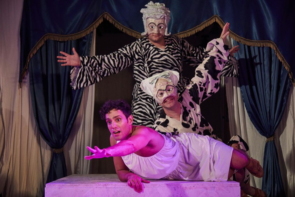 연극 공연 중 동물을 주제로 한 의상을 입은 세 명의 공연자가 한 명은 앞에 누워 있고 두 명은 뒤에 서 있습니다.