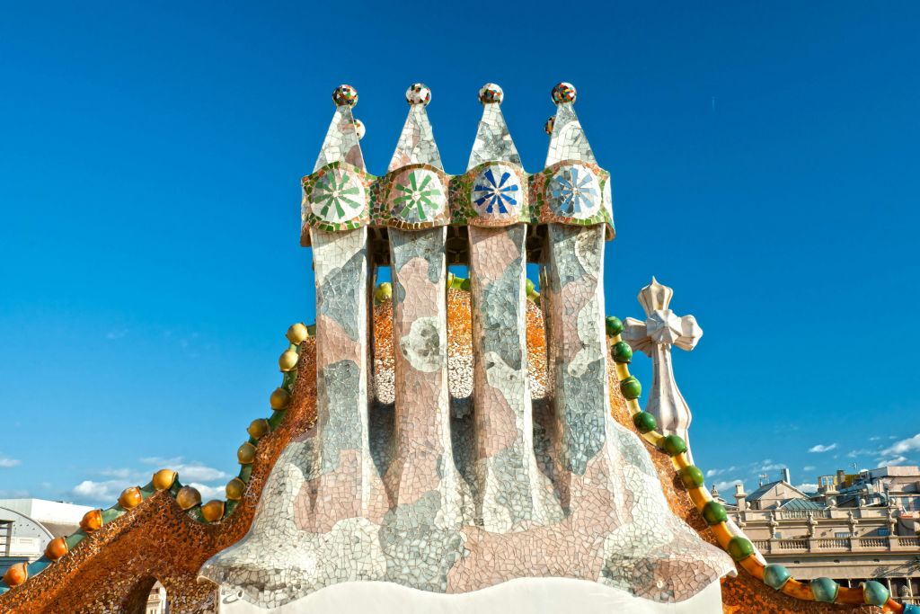 맑고 푸른 하늘을 배경으로 옥상에 다채로운 디자인의 모자이크 마감 굴뚝이 있습니다.