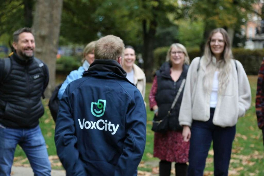 한 명은 "boxCity" 가 새겨진 재킷을 입고, 다른 한 명은 웃으며 뒤에 나무가 있는 잔디 위에 서 있습니다.