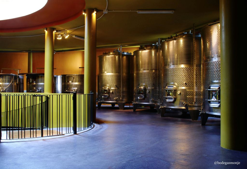 스테인리스 스틸 발효 탱크, 원형 난간, 광택이 나는 파란색 바닥이 있는 객실입니다.