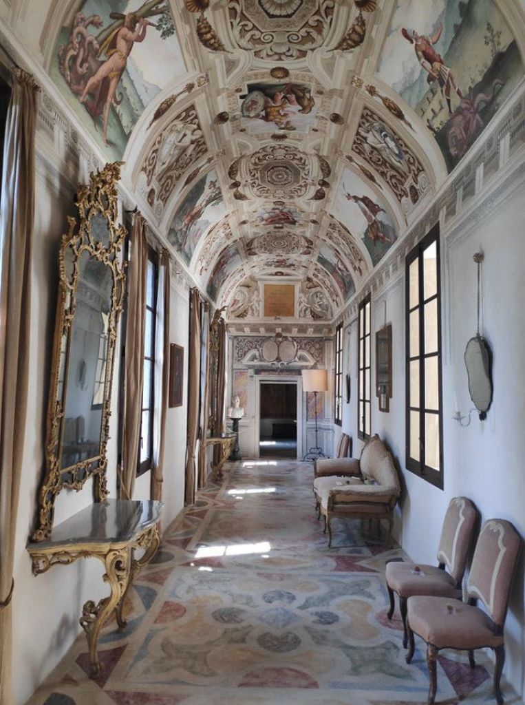 정교한 천장 벽화, 금박으로 마감된 거울, 앤티크 가구, 자연 채광이 들어오는 커다란 창문이 있는 화려한 복도.