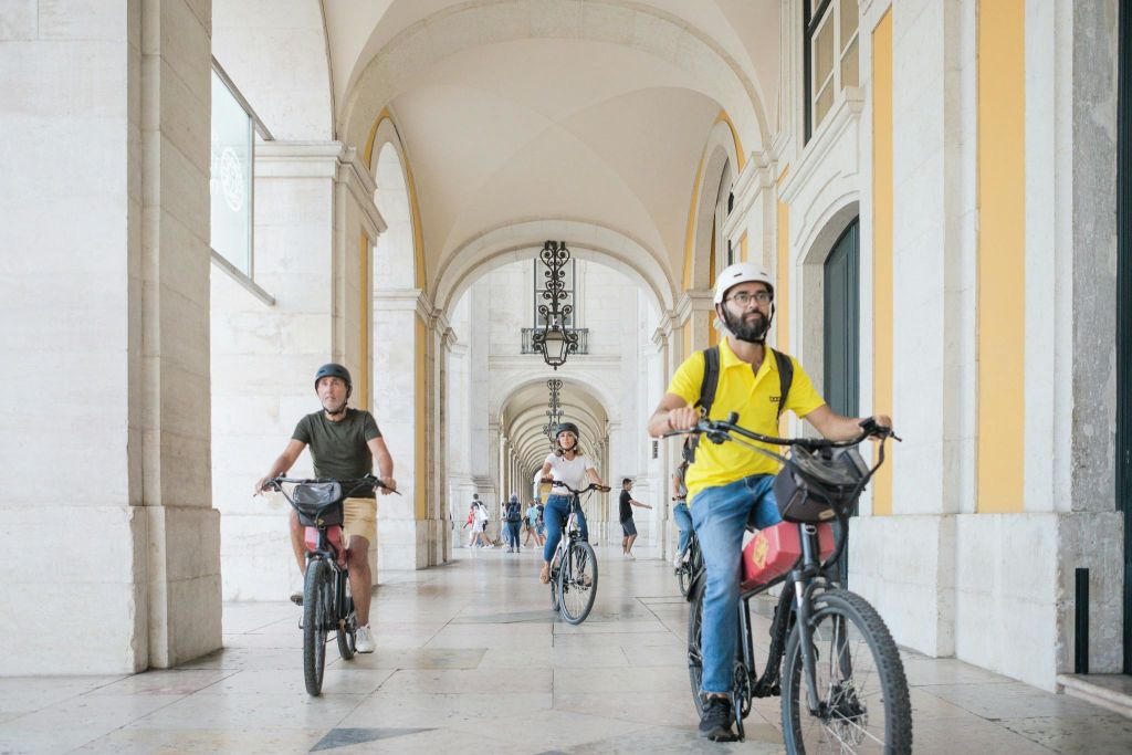 커머스 스퀘어에 들러 리스본에서 전동 자전거 투어를 즐기는 관광객.