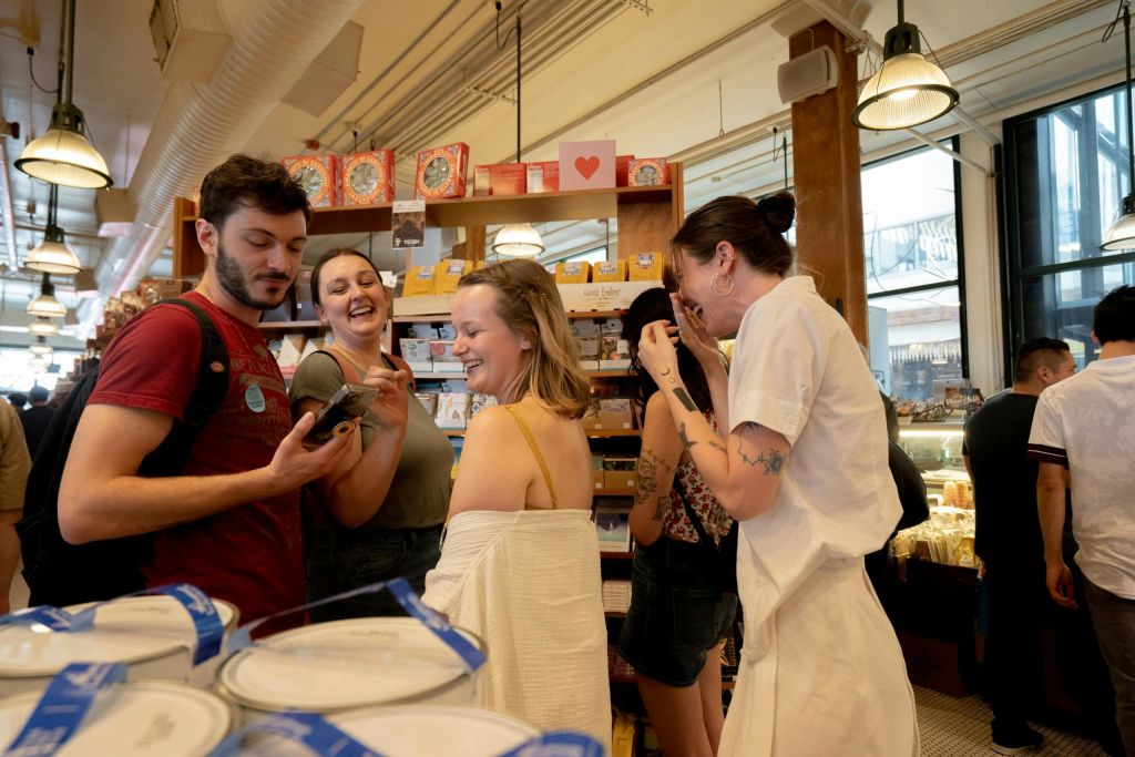 매장 내부에서 제품 진열대를 배경으로 미소 짓고 상호 작용하는 사람들.