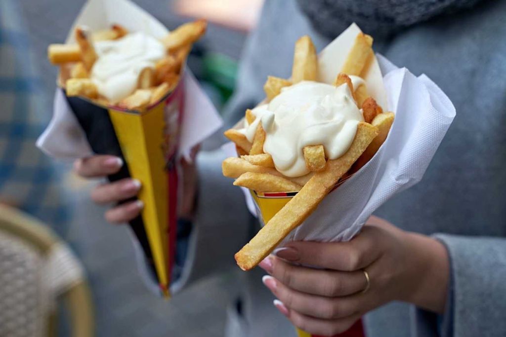 마요네즈를 얹은 감자튀김 콘을 들고 있는 두 사람.