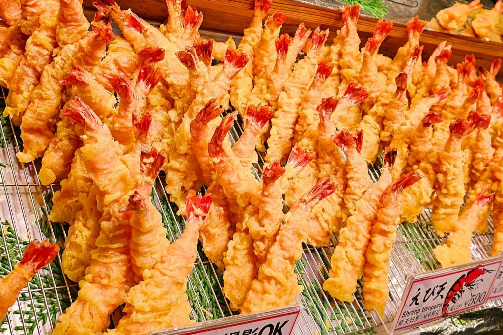 여러 조각의 새우 튀김이 금속 랙에 줄지어 배치되어 서빙할 준비가 되었습니다.