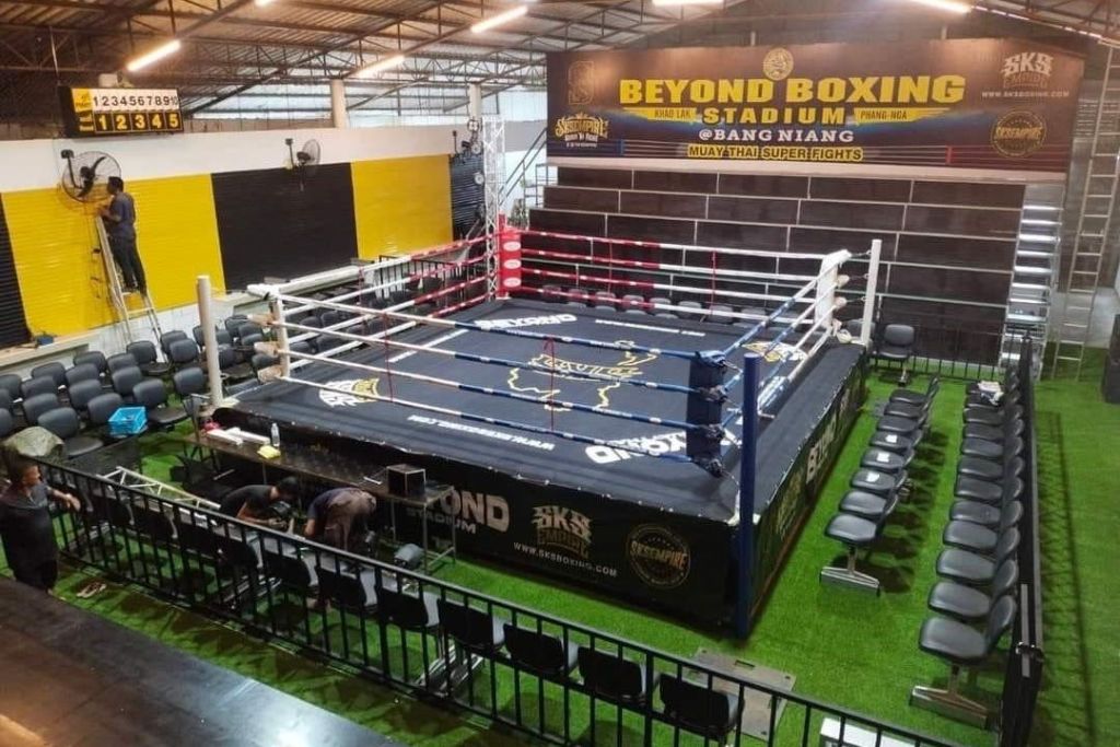 경기장 분위기의 무에타이 복싱 링으로, 좌석으로 둘러싸여 있으며 "Beyond Boxing" 의 간판이 눈에 띕니다.