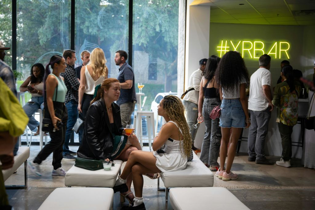 커다란 창문과 흰색 가구로 꾸며진 현대적인 실내 환경에서 사람들과 어울리고 있습니다.