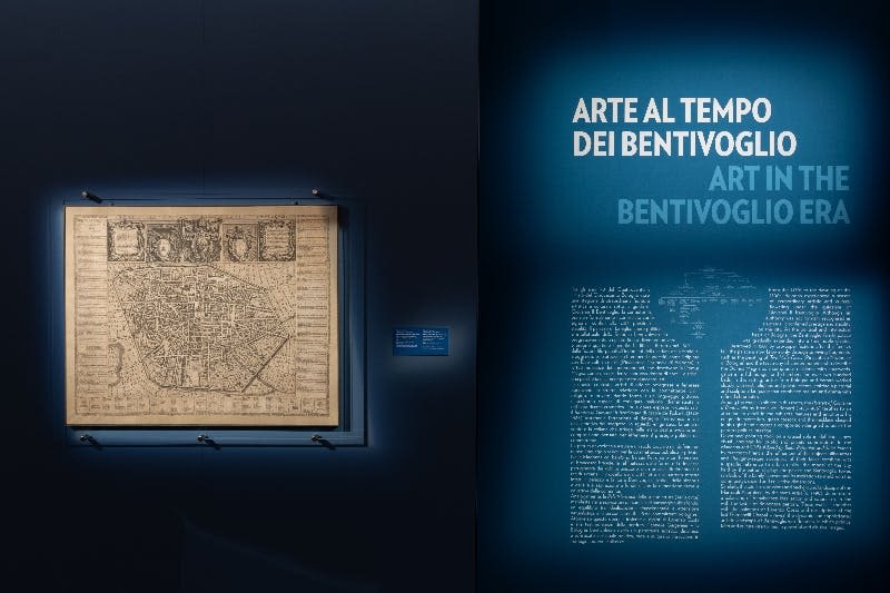 나무 바닥, 벽 예술, 디테일한 천장, 현대적인 조각품이 전시된 박물관 갤러리입니다.