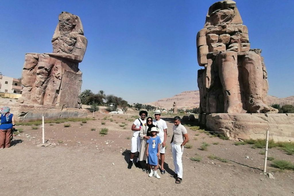 고객들은 멤논의 거상 앞에 서 있습니다.