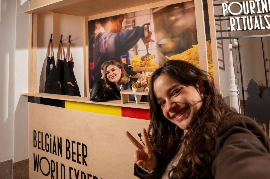 감자튀김과 활기찬 배경이 있는 음식 가판대에서 셀카를 찍기 위해 미소를 짓고 있는 두 여성.