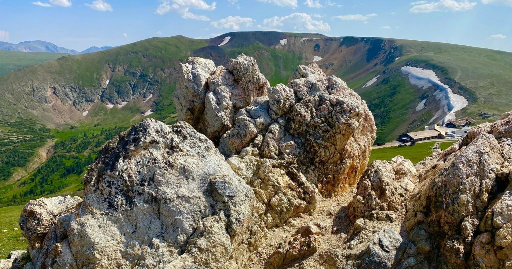 푸른 언덕과 푸른 하늘을 배경으로 전경의 들쭉날쭉한 바위 지형.