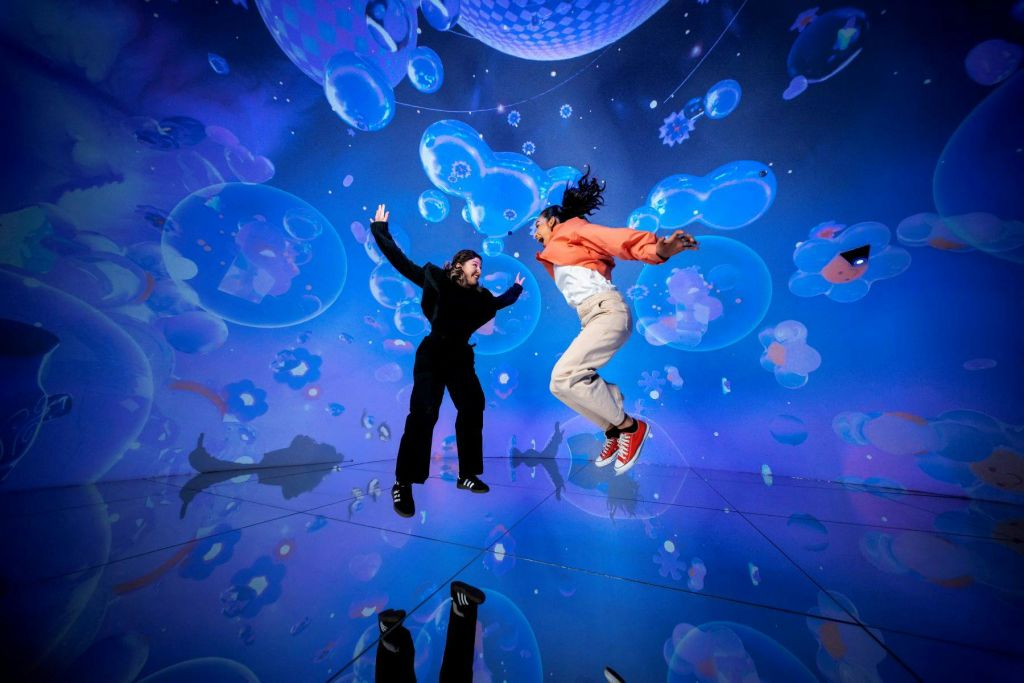 화려한 거품과 반짝이는 불빛이 있는 활기차고 몰입감 넘치는 환경에서 즐겁게 뛰어노는 두 사람.