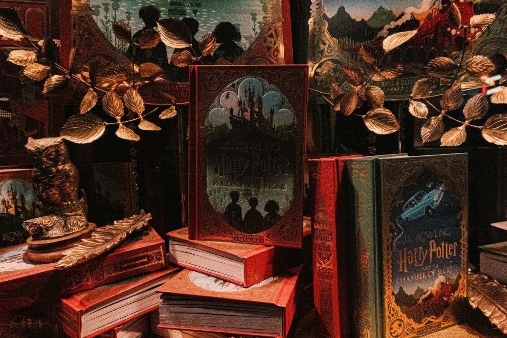 장식용 나뭇잎으로 둘러싸인 "해리 포터와 철학자의 돌" 을 포함하여 화려하게 디자인된 책이 전시되어 있습니다.