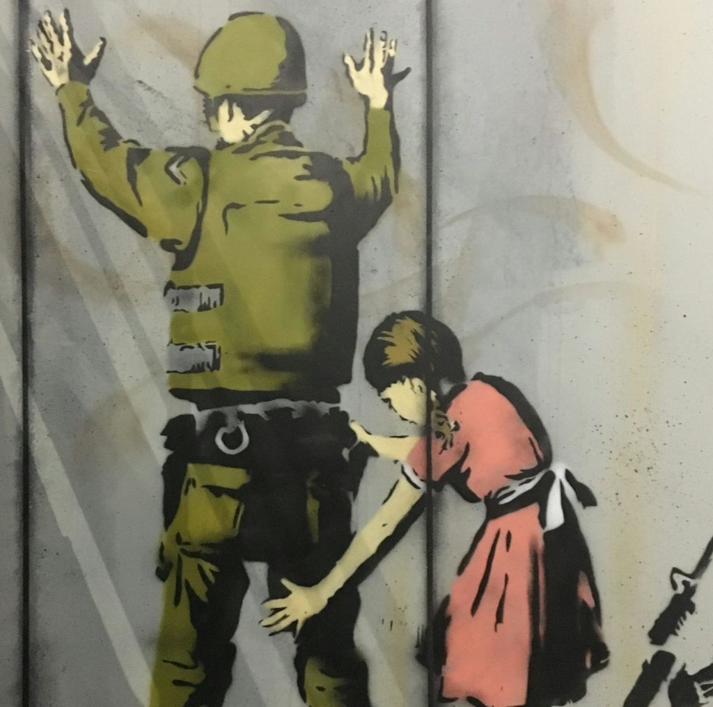 어린 소녀에게 당한 병사의 낙서. 병사는 양손을 위로 올리고, 소녀는 분홍색 드레스를 입습니다.