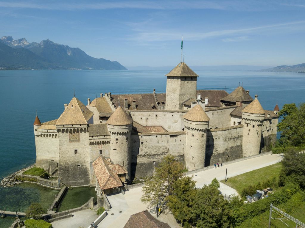 제네바 호숫가에 있는 중세 성인 샤토 드 시용 (Château de Chillon) 의 조감도, 먼 산과 맑은 하늘.