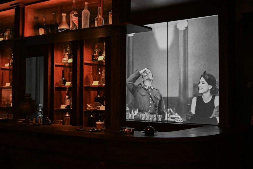 영사된 영화가 있는 주류 선반과 스크린.