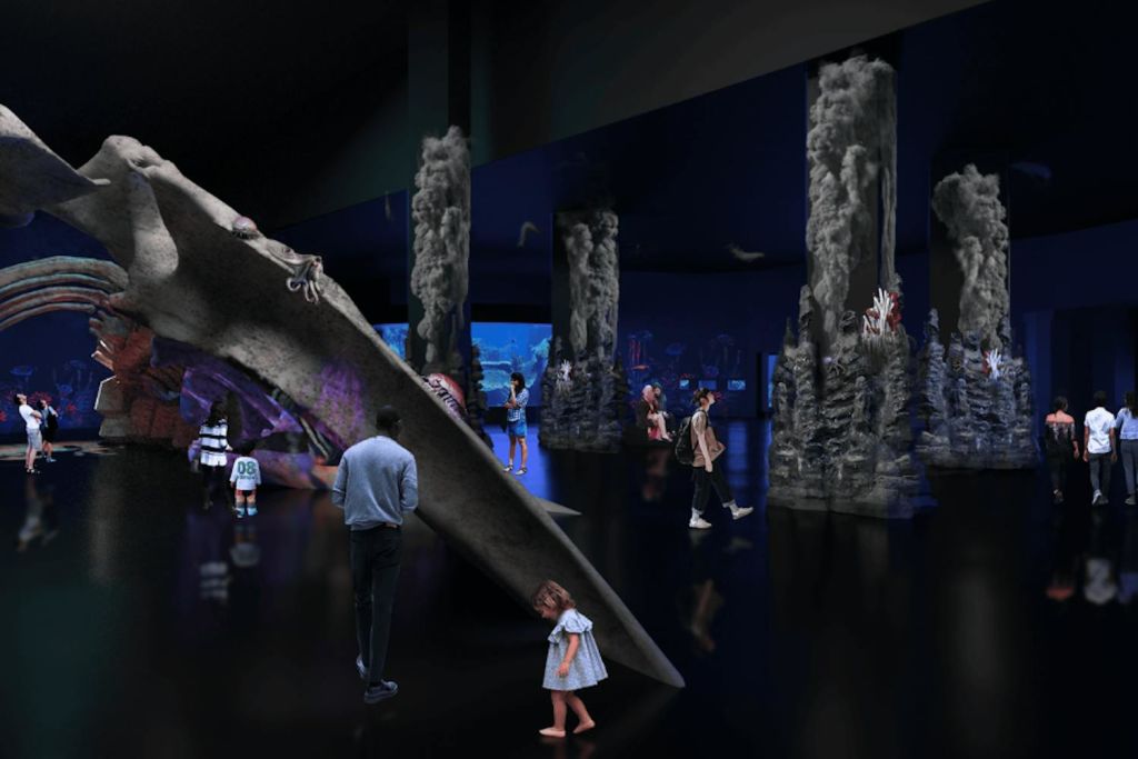 대형 수중 화석 디스플레이와 수중 경치가 있는 조명이 희미한 수족관에서 전시회를 걷고 관찰하는 사람들.