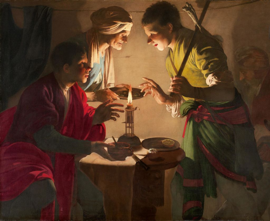 한 촛불이 켜진 작은 테이블에 세 남자가 모여들었고, 한 남자는 막대기를 들고, 다른 남자는 음료를 붓고 있었다.