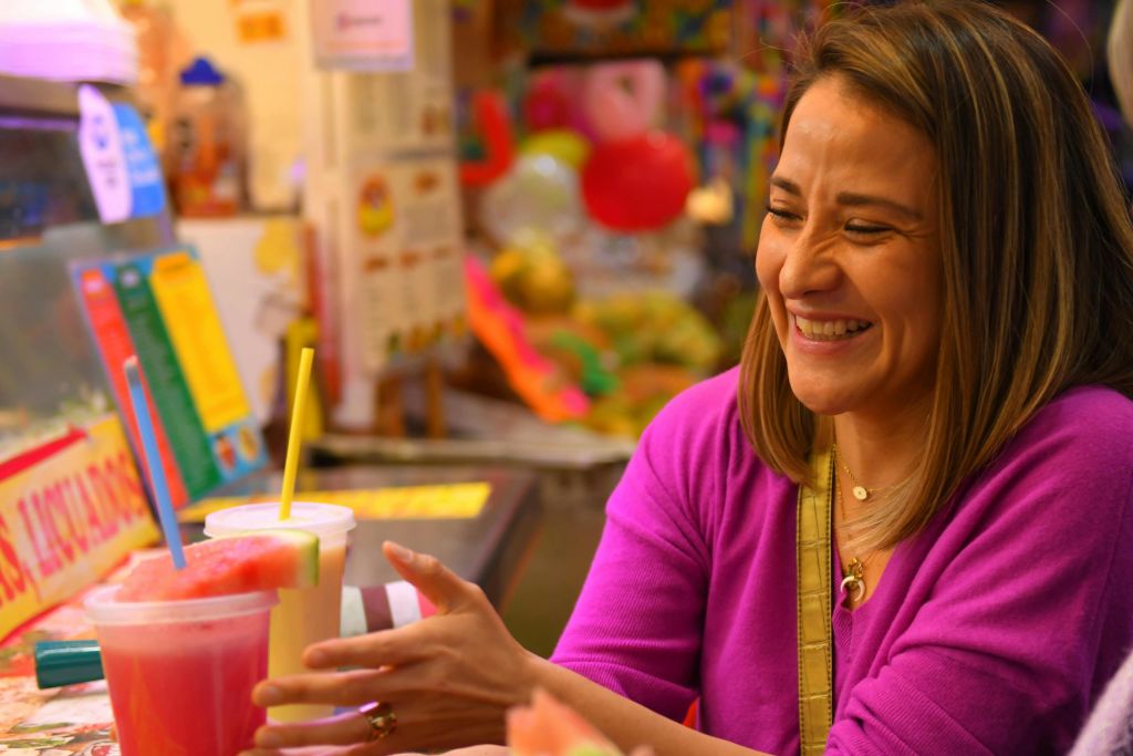 한 여성이 시장 안에서 신선한 과일이 첨가된 물을 즐기고 있습니다.