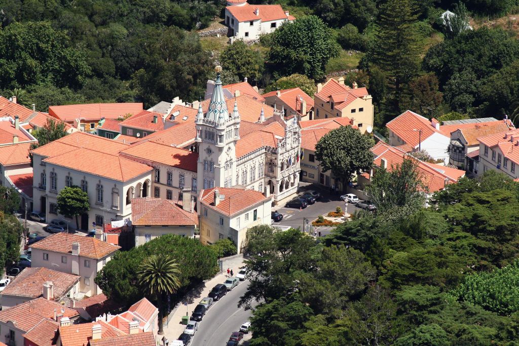 화창한 날에 붉은 지붕의 집과 나무로 둘러싸인 타워가 있는 역사적인 건물의 공중 전망.