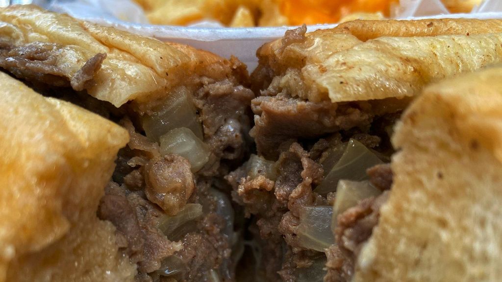 각질이 있는 크러스트가 있는 미트 파이의 클로즈업으로 잘게 썬 고기와 잘게 썬 양파를 볼 수 있습니다.