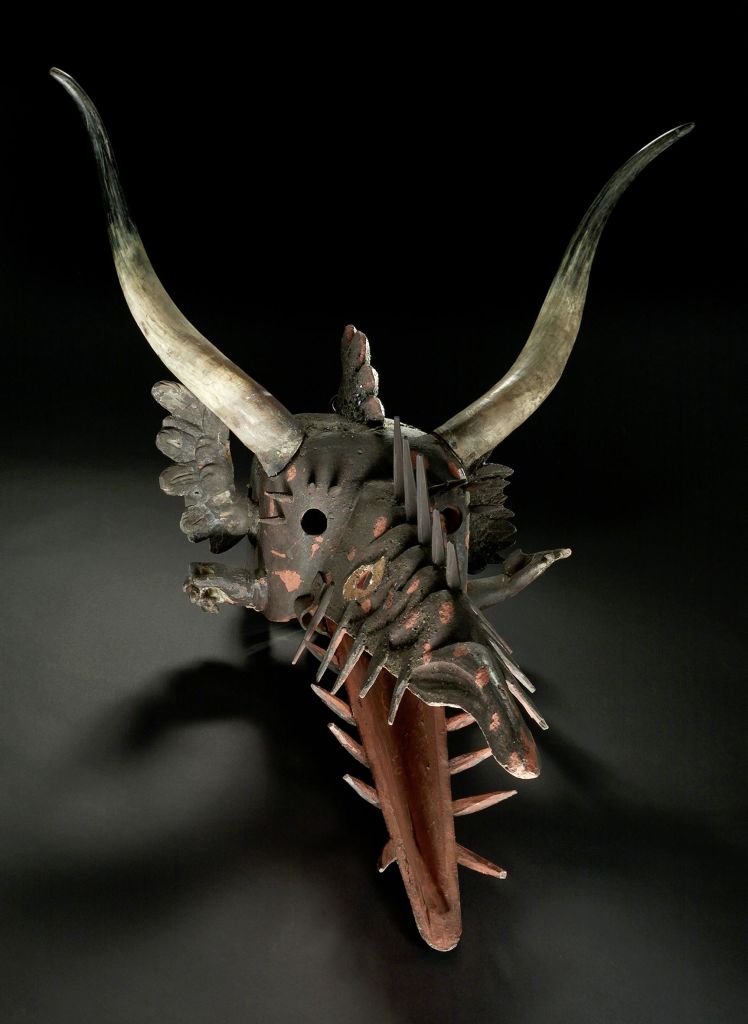 뾰족한 디테일과 위협적인 특징이 있는 어둡고 뿔이 있는 마스크가 검은색 배경에 설정되어 있습니다.