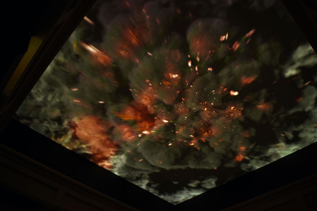 아래에서 바라본 격렬한 폭발과 어두운 연기가 프레임 전체를 가득 채우고 있는 드라마틱한 묘사.