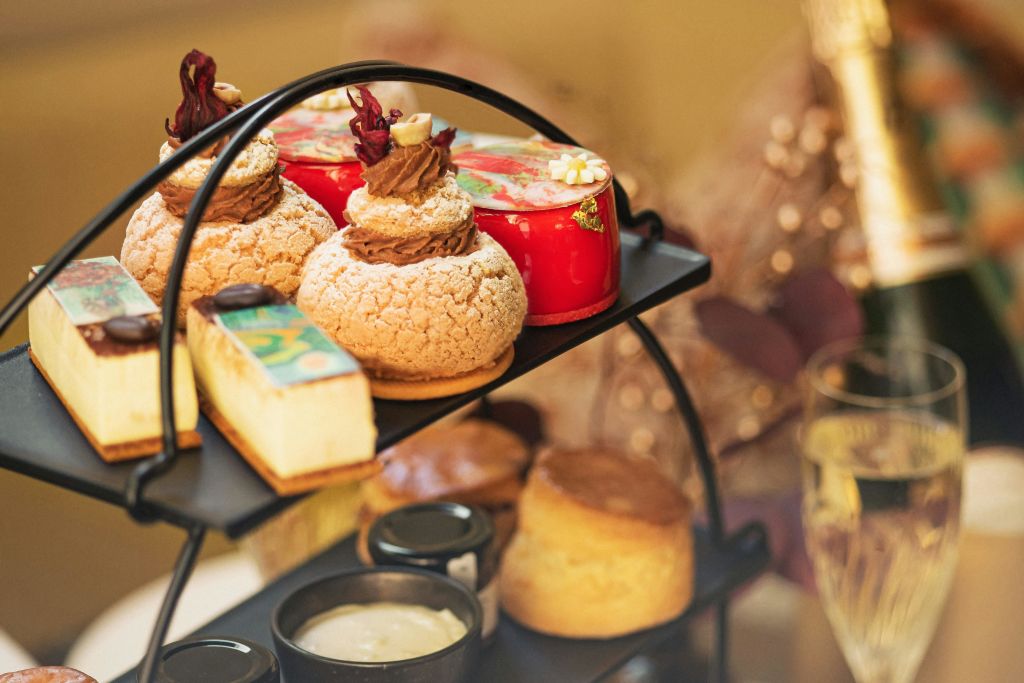 크림 퍼프, 레드 케이크, 스콘, 작은 크림병 등 다양한 페이스트리가 담긴 다단 트레이입니다.