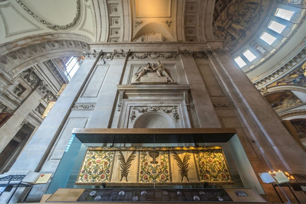 정교한 조각, 높은 아치형 천장, 다채로운 예술품이 있는 유리 디스플레이 케이스가 있는 웅장한 건물의 화려한 내부.