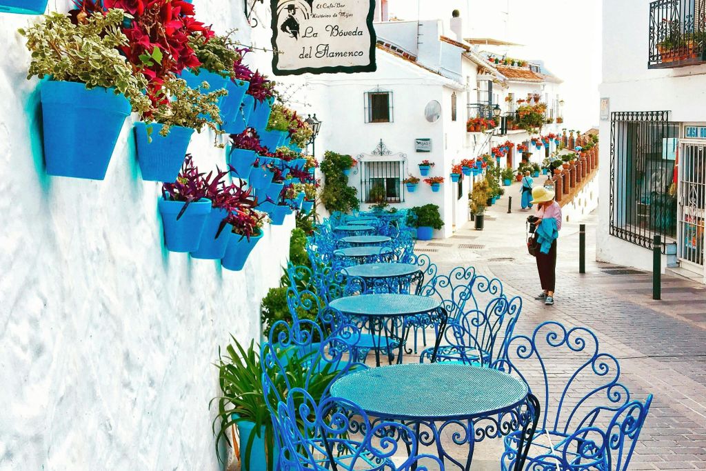 미하스푸에블로에서 푸른 의자와 화분이 있는 다채로운 거리 카페