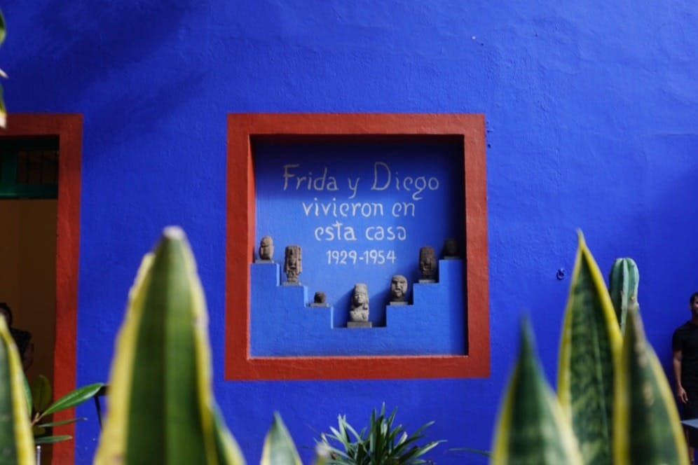 "Frida y Diego vivieron en esta casa 1929-1954" 라는 점토 피규어와 텍스트가 있는 파란색 벽면 인셋.
