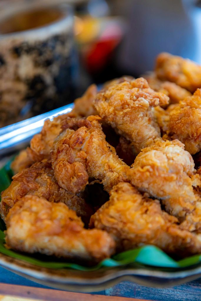 흐릿한 배경과 함께 바삭바삭하게 튀긴 치킨 조각이 쌓인 접시의 클로즈업.