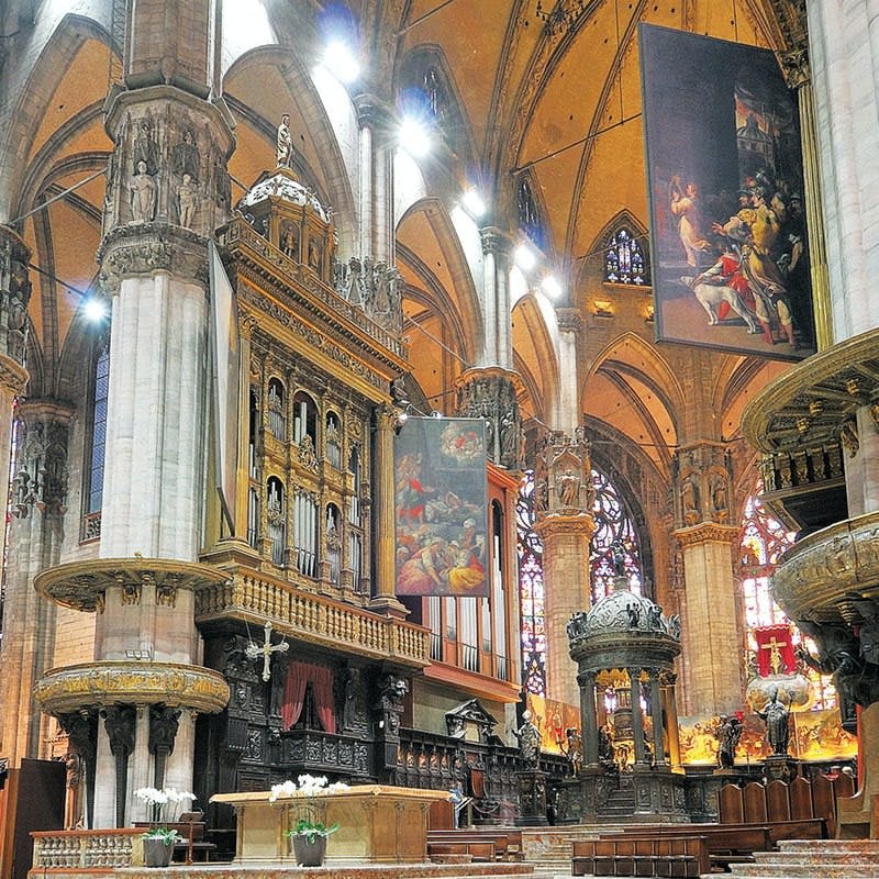 화려한 기둥, 스테인드글라스 창문, 종교 회화, 정교한 목조 및 석조 조각이 있는 대성당 내부.