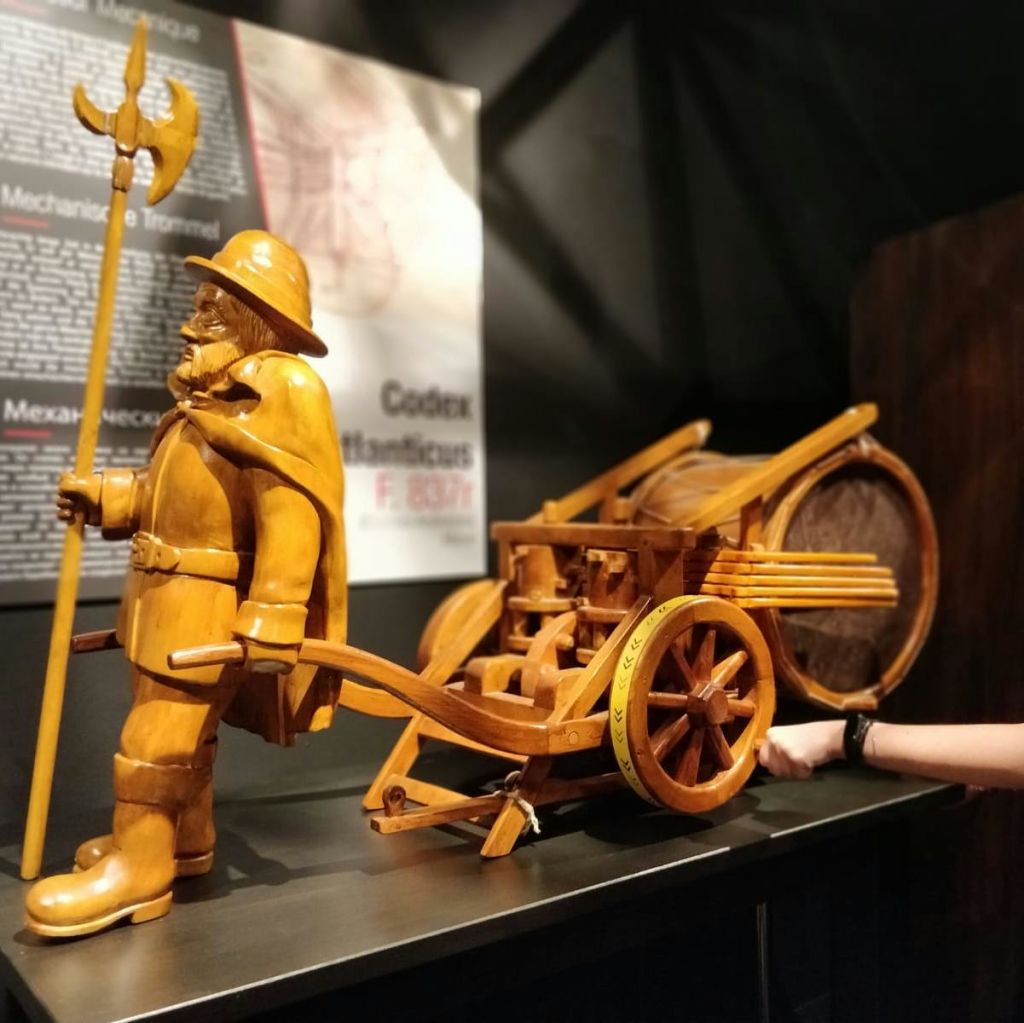 박물관에 전시된, 바퀴 달린 대포를 당기는 할버드가 있는 중세 군인의 목조 조각상입니다.
