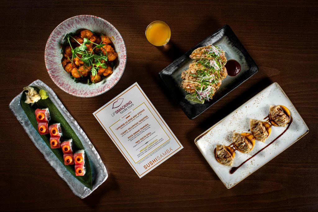 다양한 도금 요리와 음료, 스시삼바의 메뉴카드가 전시된 테이블입니다.