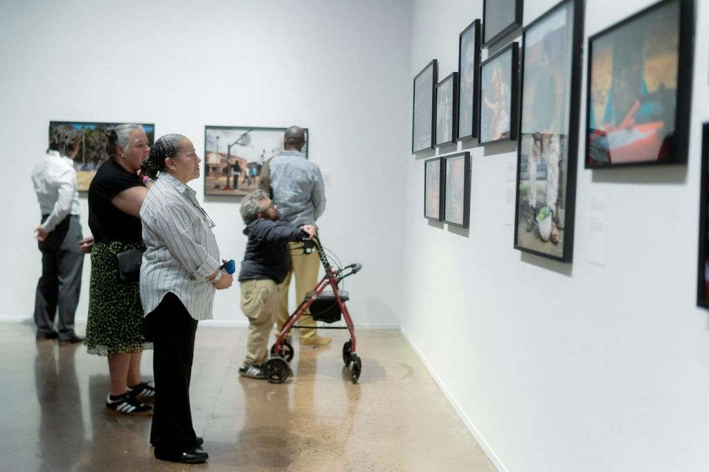 사진 작품이 있는 모랄레스 갤러리 전경과 작품을 감상하는 게스트 몇 명