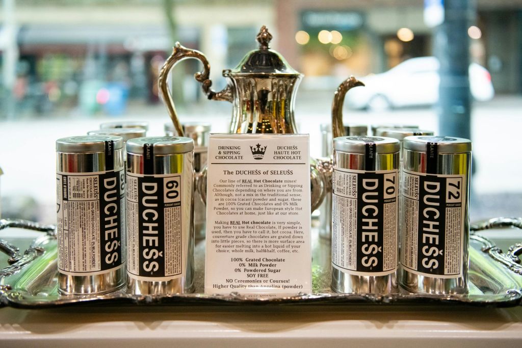 매장 창문의 트레이에 은색 주전자와 정보 카드가 있는 '공작 부인' 이라고 적힌 양철통이 진열되어 있습니다.