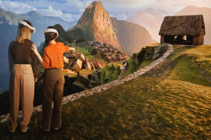 VR 헤드셋을 착용한 사람은 산악 배경과 오래된 구조물이 있는 마추픽추를 닮은 가상 풍경을 가리킵니다.