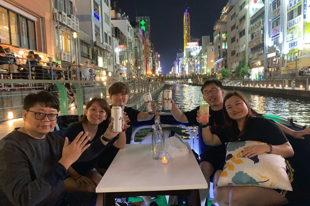 운하 보트를 타고 테이블에 앉아 음료를 들고 불이 켜진 건물과 밤에는 활기찬 분위기를 즐길 수 있습니다.