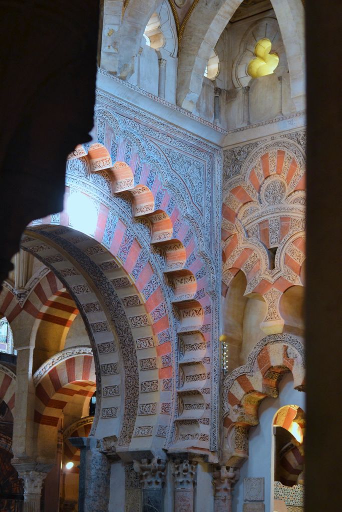 역사적인 장식 건물 내부에 빨간색과 흰색 줄무늬가 있는 정교하고 정교한 패턴의 아치.