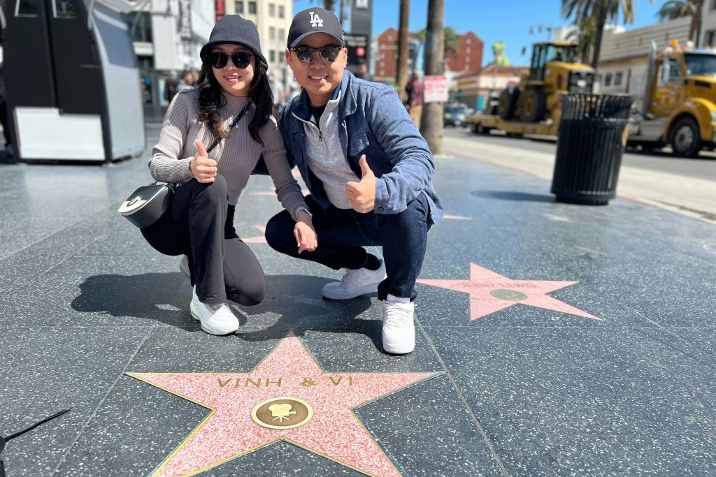 할리우드 명예의 거리 (Walk of Fame) 지역 관광객은 사진 촬영을 위해 자신만의 레플리카 스타에 만족합니다. # 커플