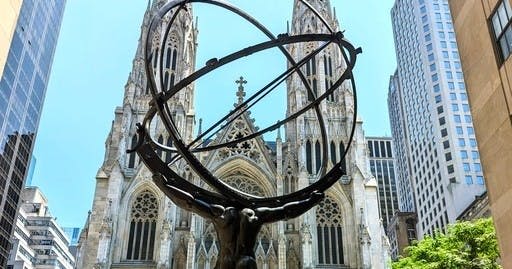 맑고 푸른 하늘 아래 고딕 양식의 대성당 앞에 천상의 반지를 끼고 있는 아틀라스 동상.