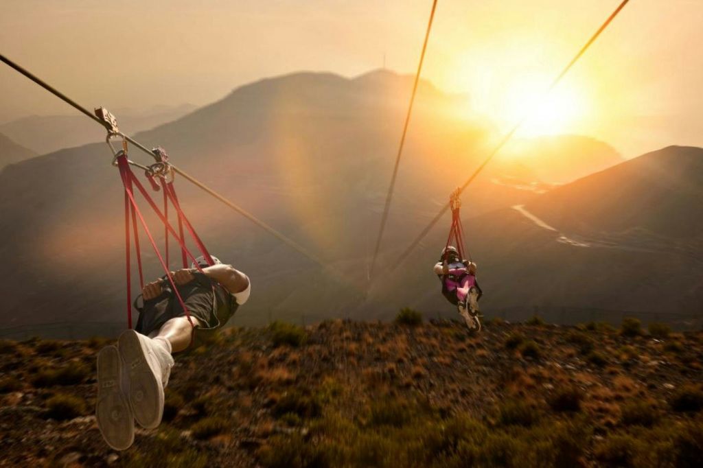노을이 지는 산악 지형에서 오렌지색과 노란색의 색조가 시선을 사로잡습니다.