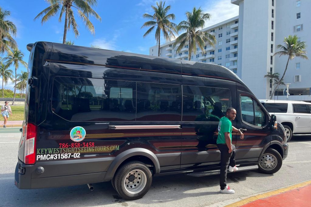 투어 가이드는 마이애미 3-in-1 시티 투어 기간 동안 오션 드라이브에서 버스로 대기합니다.